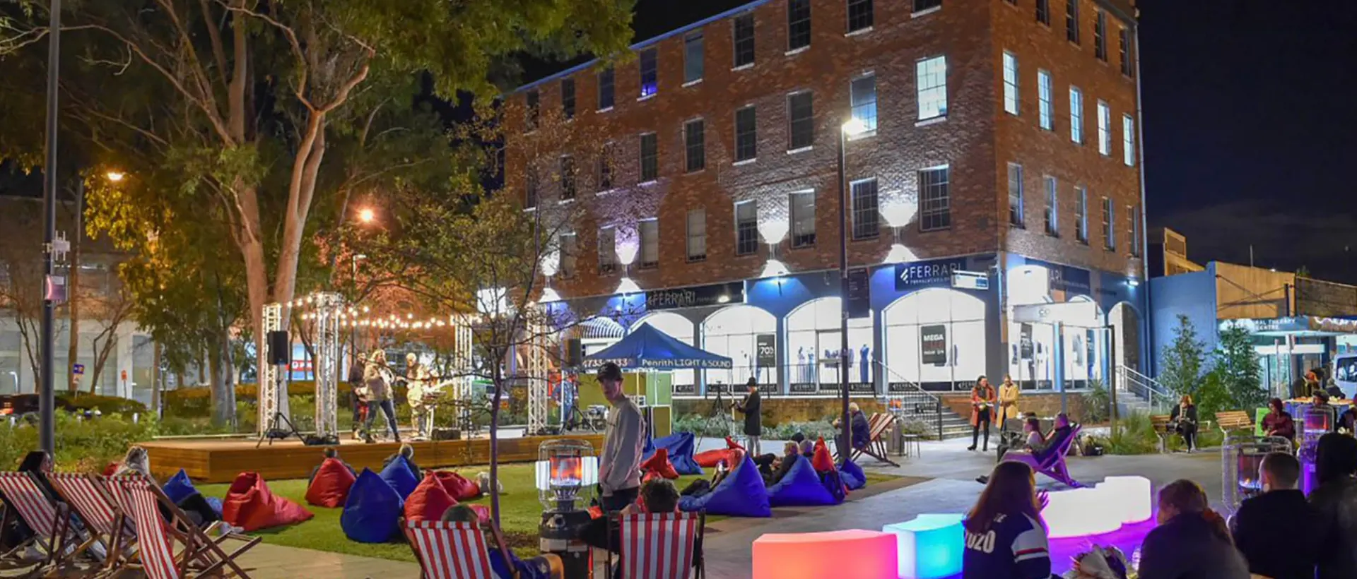 Triangle Park in the Penrith city centre at night with live music, deck chairs and heritage brick buildings — an area serviced by Mould Hunters